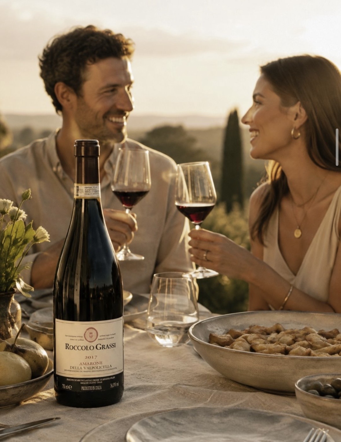 Couple sharing Roccolo Grassi Amarone at an outdoor table at sunset
